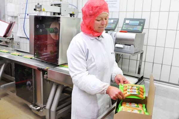 Die vakuumverpackten Bio-Wiener Würstchen werden für den Transport zum Handel in Kartons verpackt.